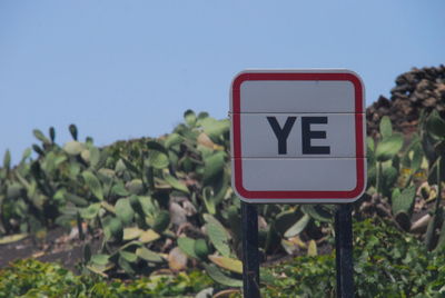 Road sign against clear blue sky