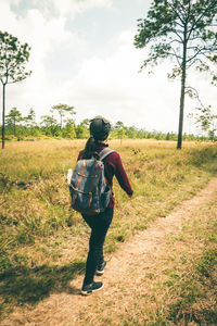 Rear view of woman walking on field