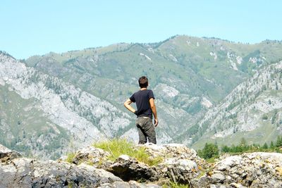 Man standing on rock looking at mountains