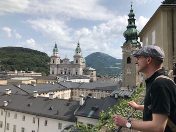 Man looking at cityscape against sky