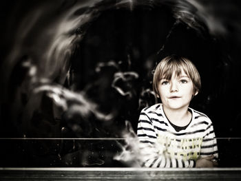 Boy playing with bubbles standing at railing