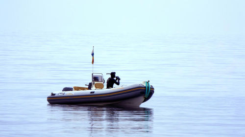 Man sitting on boat in sea