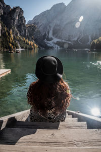 Rear view of woman looking at lake against mountains