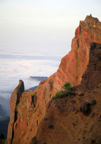 Scenic view of cliff by sea against sky