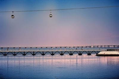 Bridge over sea against clear sky