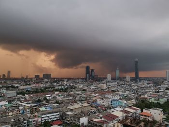 Buildings in city against sky during sunset