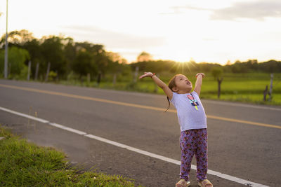 Side view of young woman walking on road