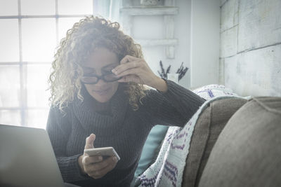 Man using mobile phone on sofa at home
