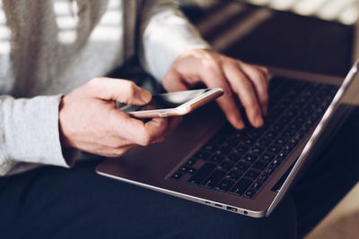 Midsection of man using mobile phone