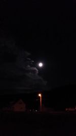 Low angle view of illuminated light against sky at night