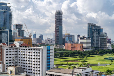 Modern buildings in city against cloudy sky