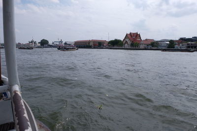 Boats in river with city in background