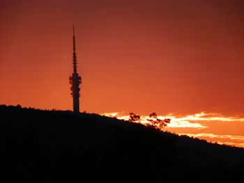 Silhouette of communications tower at sunset