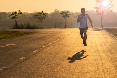 Full length of man on road against sky during sunset