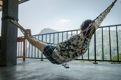 Woman relaxing in hammock at balcony