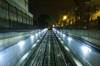 Railroad tracks in city at night