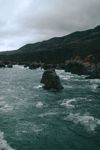 Scenic view of sea and mountains against sky