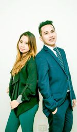 Portrait of young couple standing against white background