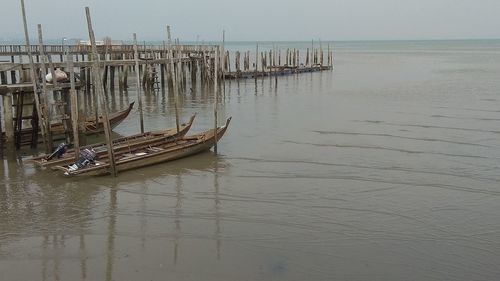 Boat moored on sea against sky