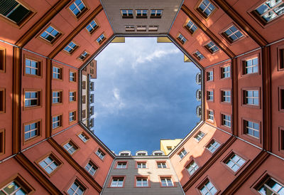 Directly below shot of building against cloudy sky