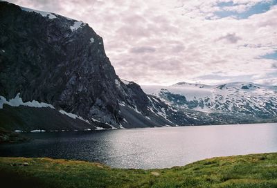 Scenic view of lake by mountains against sky