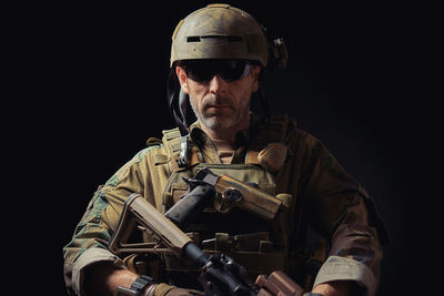Portrait of mature man in military uniform against black background