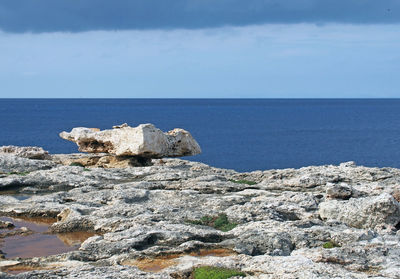 Rock formations by sea against sky