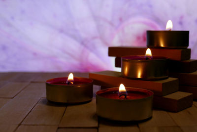 Close-up of illuminated tea light candles on table