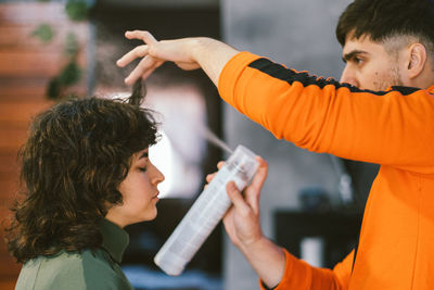 Hairdresser sprying female haircut trend