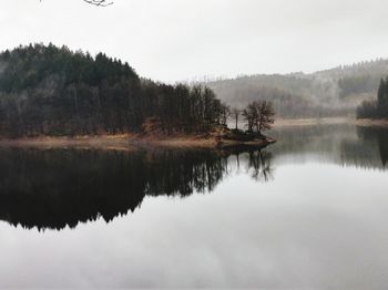 Reflection of trees in lake against sky