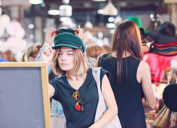 Young women standing at store in city