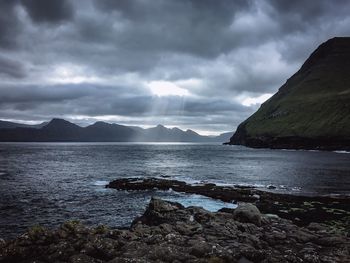 Scenic view of sea and mountains against sky