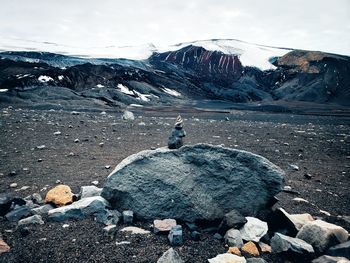 Snow covered rocks against sky