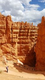 Hikers visiting navajo loop at bryce canyon national park against sky