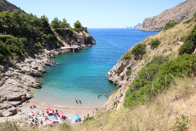 Bathers on the small beach of the bay of ieranto in the province of naples, italy.