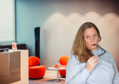 Young woman using phone while sitting on table