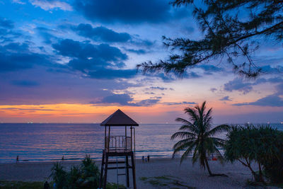 View of lifeguard hut at sea against sky during sunset