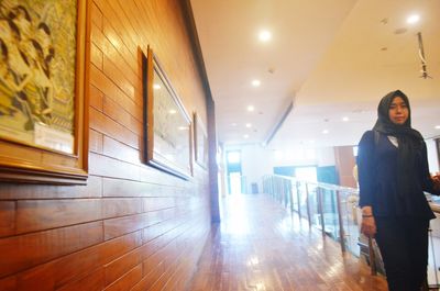 Full length of woman standing in illuminated building