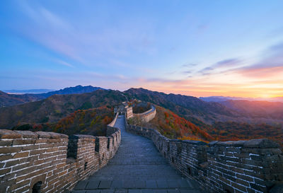 Footpath leading towards mountain during sunset