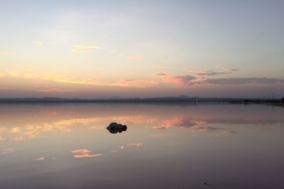 Boats in calm sea at sunset