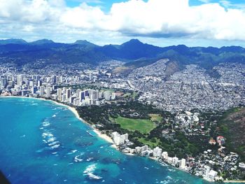 Aerial view of city against cloudy sky
