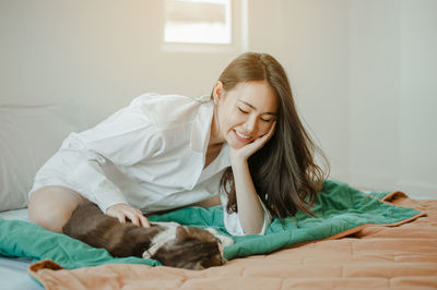 Young woman lying down on bed at home