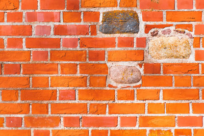 Beautiful background of old vintage red or orange brick wall with stones