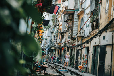 People on street amidst buildings in city