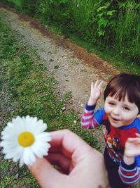 Woman holding white flowering plants in park