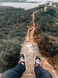 Low section of man standing on mountain 