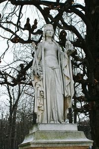 Low angle view of buddha statue against trees