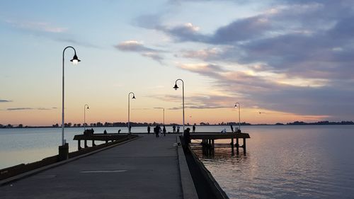 Pier over sea against sky during sunset