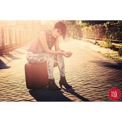 Full length of woman sitting on road against sky