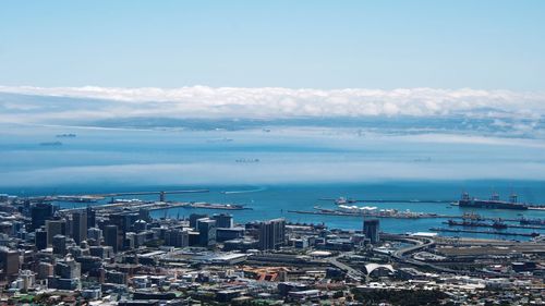 High angle view of cityscape by sea against sky